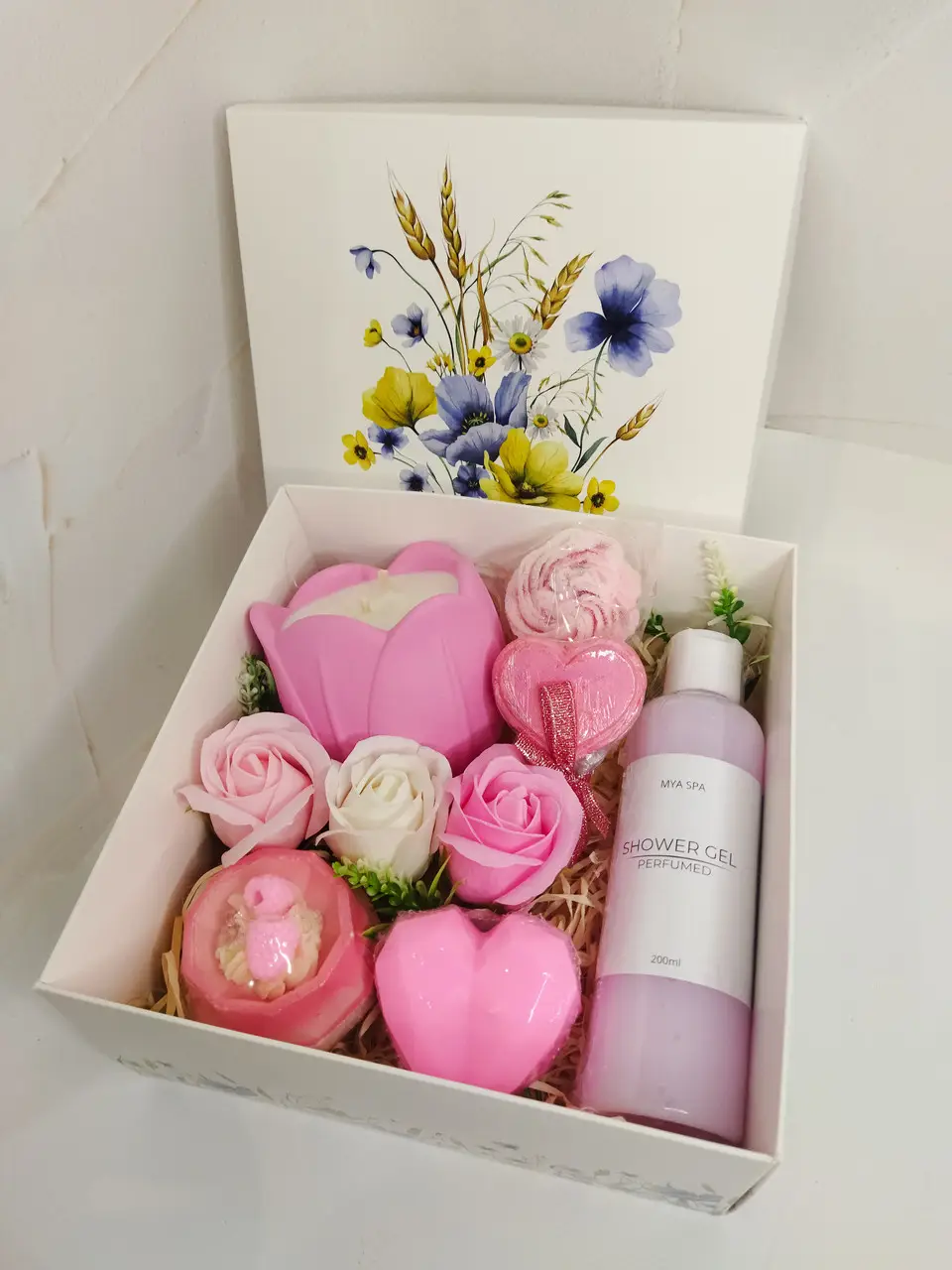 Spa composition with towels, aroma oil, candle and roses on wood