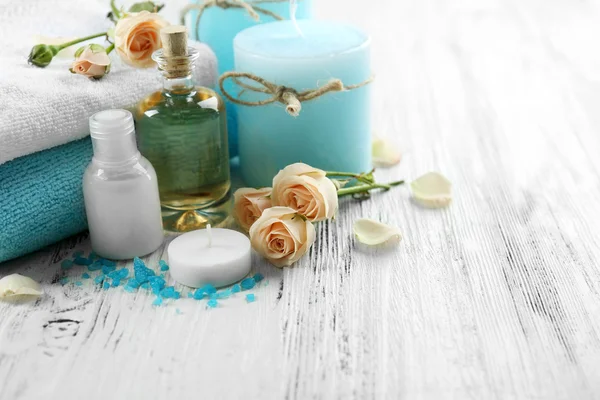 Spa composition with lotion, towel, candle and roses
